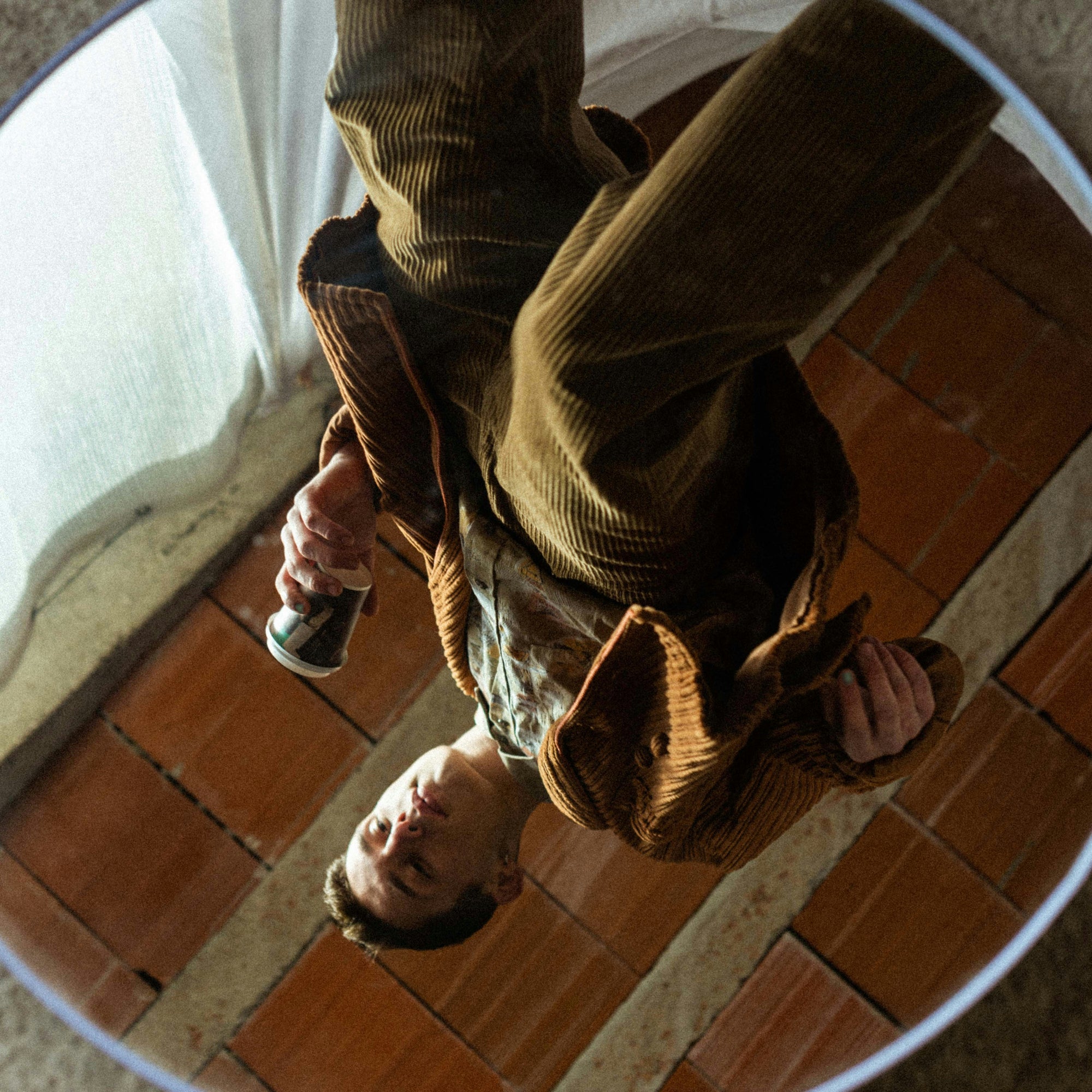 Man in a mirror holding a coffee cup and wearing Wanderer X nail polish.