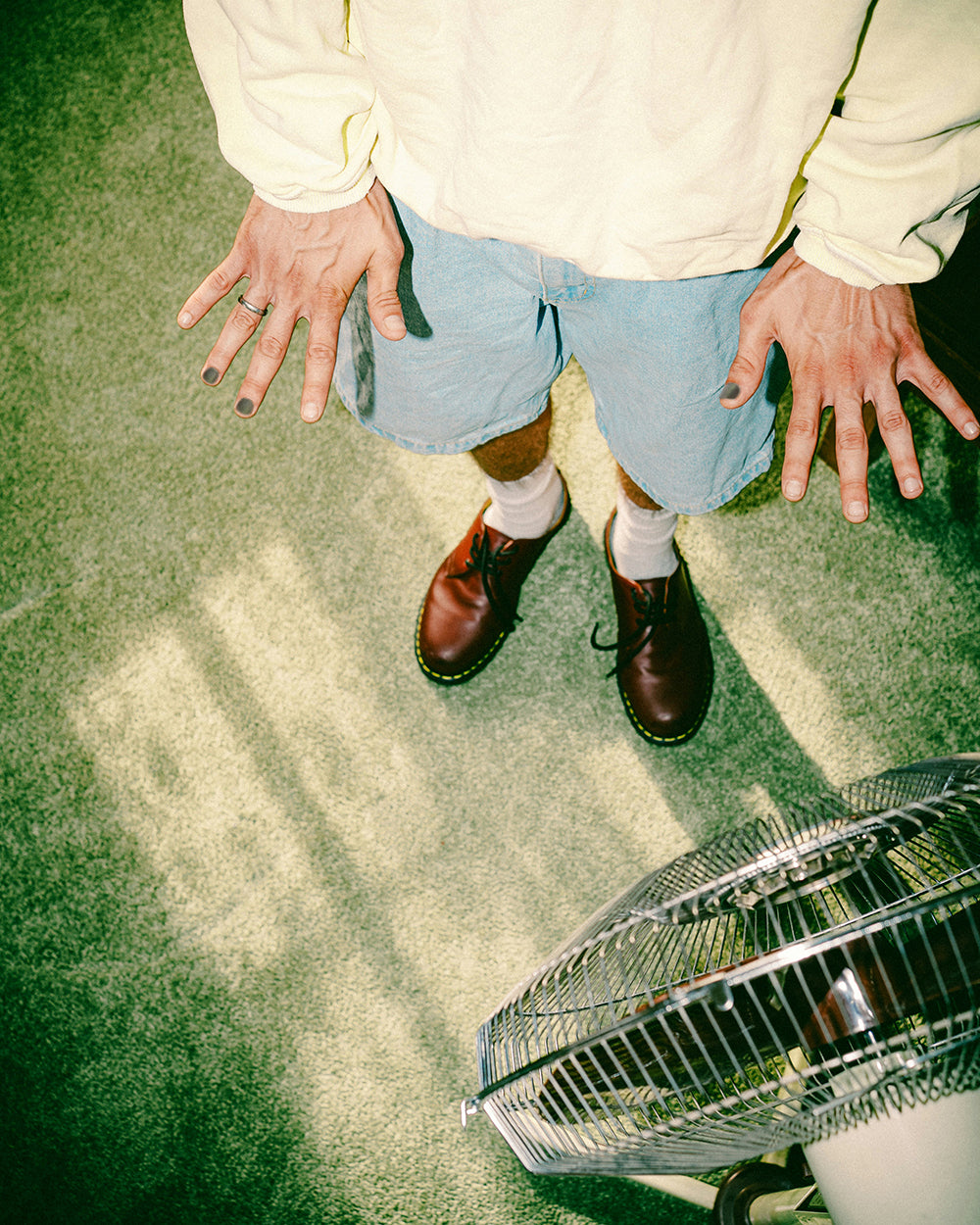 Man posing in front of a fan showing his XY nail polish