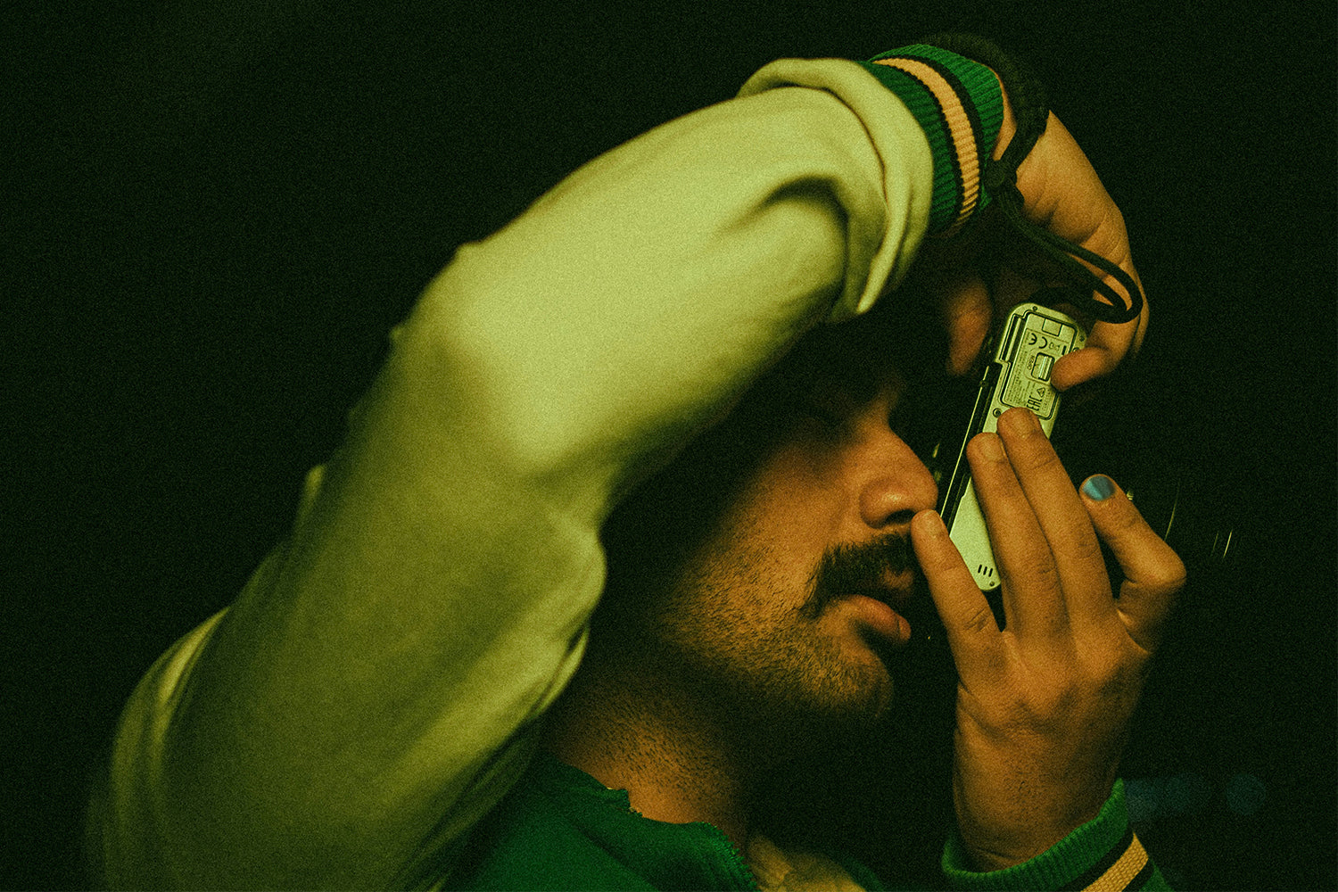 Man taking a picture with a camera and wearing XY nail polish